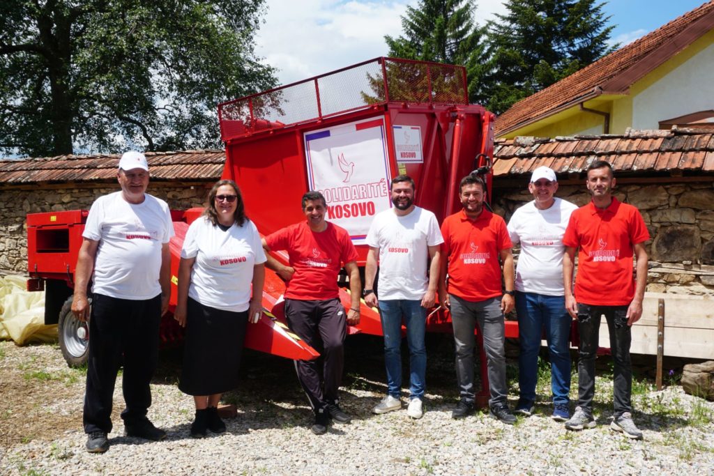 L'équipe de la soupe populaire de Novo Brdo et les volontaires de Solidarité Kosovo devant une arracheuse de maïs offerte par l'association.